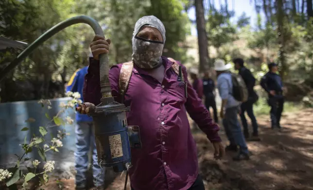 A man shows a pump removed from an unlicensed water intake as his group of residents, farmworkers and small-scale farmers from Villa Madero dismantle illegal water taps in the mountains of Villa Madero, Mexico, Wednesday, April 17, 2024. As a drought in Mexico drags on, angry subsistence farmers have begun taking direct action on thirsty avocado orchards and berry fields of commercial farms that are drying up streams in the mountains west of Mexico City. (AP Photo/Armando Solis)