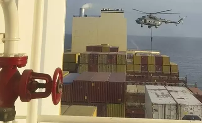 This image made from a video provided to The Associated Press by a Mideast defense official shows a helicopter raid targeting a vessel near the Strait of Hormuz on Saturday, April 13, 2024. A video seen by The Associated Press shows commandos raiding a ship near the Strait of Hormuz by helicopter Saturday, an attack a Mideast defense official attributed to Iran amid wider tensions between Tehran and the West. The Mideast defense official spoke on condition of anonymity to discuss intelligence matters. (AP Photo)
