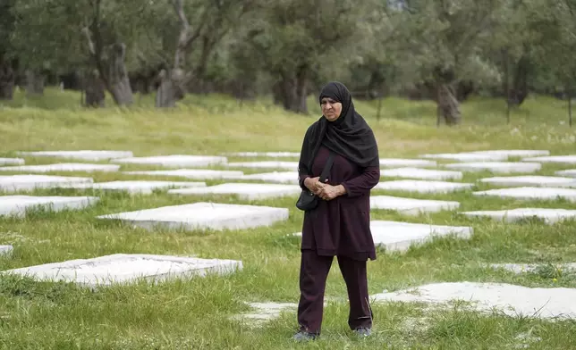 A woman walks at the cemetery in Kato Tritos village on the northeastern Aegean Sea island of Lesbos, Greece, on Wednesday, April 17, 2024. After years of neglect, a primitive burial ground for refugees who died trying to reach Greece's island of Lesbos has been cleaned up and redesigned to provide a dignified resting place for the dead. (AP Photo/Panagiotis Balaskas)