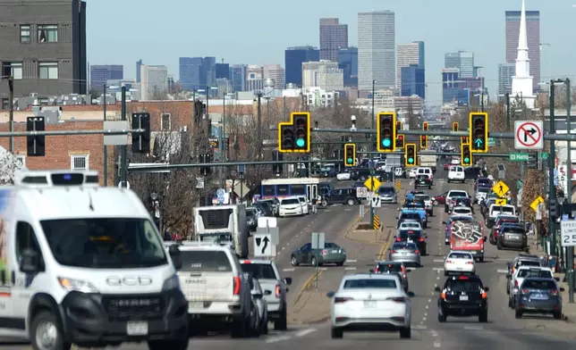 FILE - Motorists move northbound along South Broadway as the skyline of Denver stands as a backdrop Monday, Feb. 12, 2024, in Englewood, Colorado. Denver has been disrupted by an influx of largely Venezuelan migrants who head north from Mexico, becoming a flashpoint in elections locally and nationally. (AP Photo/David Zalubowski, File)