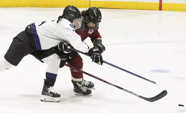 Minnesota's Sofie Jacques, left, and Montreal's Sarah Bujold vie for the puck during the second period of a PWHL hockey game Thursday, April 18, 2024, in Montreal. (Christinne Muschi/The Canadian Press via AP)