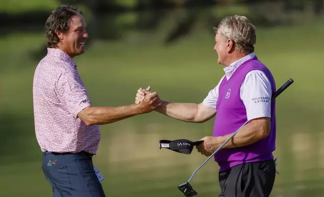 Stephen Ames shakes hands with Paul Broadhurst after finishing the final round of the Mitsubishi Classic senior golf tournament at TPC Sugarloaf, Sunday, April 28, 2024, in Duluth, Ga. (Miguel Martinez/Atlanta Journal-Constitution via AP)