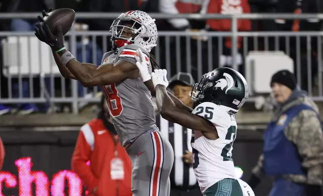 FILE - Ohio State receiver Marvin Harrison, left, catches a touchdown pass over Michigan State defensive back Chance Rucker during the first half of an NCAA college football game Saturday, Nov. 11, 2023, in Columbus, Ohio. Harrison Jr. is a possible first round pick in the NFL Draft.(AP Photo/Jay LaPrete, File)