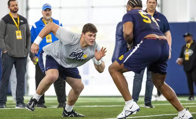 FILE - Notre Dame offensive tackle Joe Alt, left, runs a drill against offensive tackle Blake Fisher, right, during NFL pro day football workouts in South Bend, Ind., Thursday, March 21, 2024. Alt is a possible first round pick in the NFL Draft.(AP Photo/Michael Caterina, File)