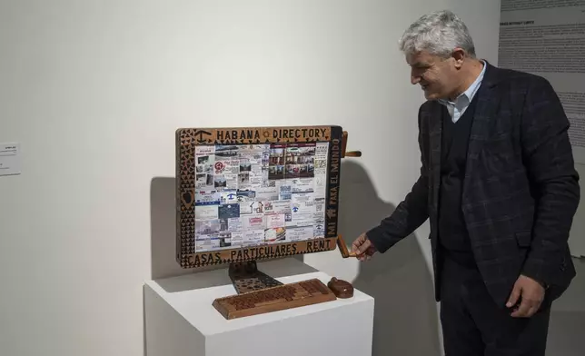 Abdelaziz El Idrissi, director of Mohammed VI Museum of Modern and Contemporary Art, interacts with an installation at a Cuban art exhibition, in Rabat, Monday, April 1, 2024. A show at Morocco's Mohammed VI Museum of Modern and Contemporary Art is one of the first exhibitions of Cuban art at an African museum. (AP Photo/Mosa'ab Elshamy)