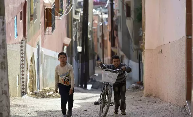 Boys who have been displaced by the earthquake walk up a hill in their hometown of Amizmiz, near Marrakech, Thursday, April 4, 2024. (AP Photo)