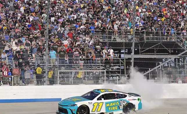 Denny Hamlin celebrates with a burnout after winning a NASCAR Cup Series auto race at Dover Motor Speedway, Sunday, April 28, 2024, in Dover, Del. (AP Photo/Derik Hamilton)