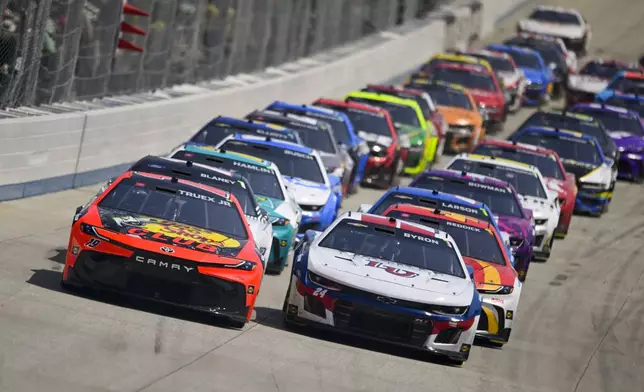 Martin Truex Jr. and William Byron lead the field into Turn 1 on a restart during a NASCAR Cup Series auto race at Dover Motor Speedway, Sunday, April 28, 2024, in Dover, Del. (AP Photo/Derik Hamilton)