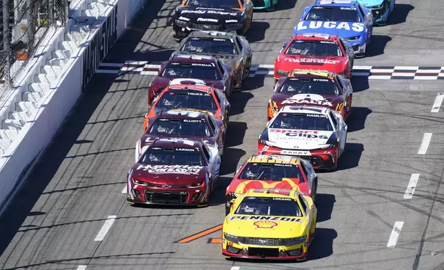 Joey Logano (22) leads Bubba Wallace (23) and Kyle Larson (5) and others during a NASCAR Cup Series auto race at Martinsville Speedway in Martinsville, Va., Sunday, April 7, 2024. (AP Photo/Chuck Burton)