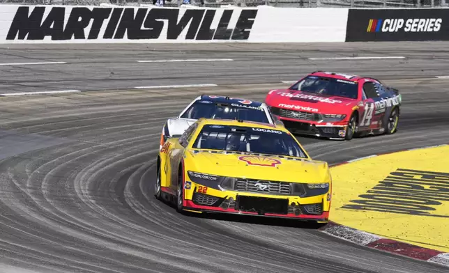 Joey Logano (22) leads Todd Gilliland (38) and Chase Briscoe (14) out of Turn 4 during a NASCAR Cup Series auto race at Martinsville Speedway in Martinsville, Va., Sunday, April 7, 2024. (AP Photo/Chuck Burton)