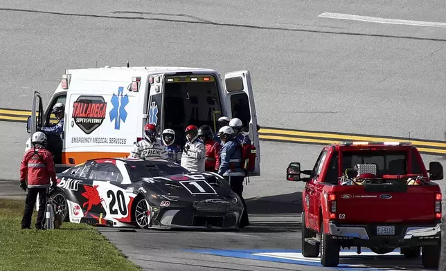 NASCAR Cup Series driver Christopher Bell (20) is helped after a collision during a NASCAR Cup Series auto race at Talladega Superspeedway, Sunday, April 21, 2024, in Talladega. Ala. (AP Photo/Greg McWilliams)