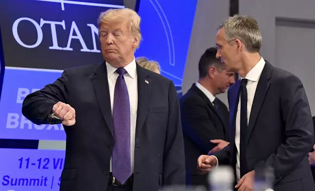 FILE - U.S. President Donald Trump checks his watch as NATO Secretary General Jens Stoltenberg stands beside him, at the Art and History Museum at the Park Cinquantenaire in Brussels, July 11, 2018. NATO is set to celebrate on Thursday, April 4, 2024, 75 years of collective defense across Europe and North America as Russia's war on Ukraine enters its third year. (AP Photo/Geert Vanden Wijngaert, File)