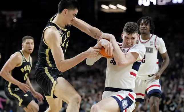 Purdue center Zach Edey, left, and UConn center Donovan Clingan battle for the ball during the first half of the NCAA college Final Four championship basketball game, Monday, April 8, 2024, in Glendale, Ariz. (AP Photo/Brynn Anderson)