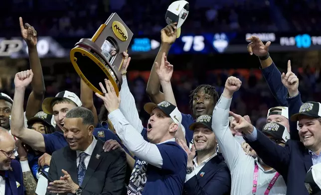 UConn head coach Dan Hurley celebrates with the trophy after their win against Purdue in the NCAA college Final Four championship basketball game, Monday, April 8, 2024, in Glendale, Ariz. (AP Photo/David J. Phillip)