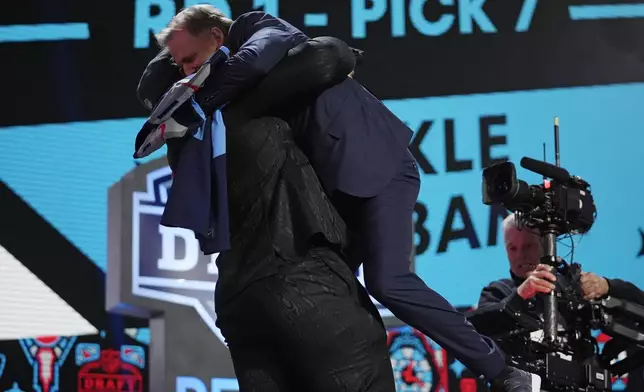 Alabama offensive lineman JC Latham embraces NFL Commissioner Roger Goodell, right, after being chosen by the Tennessee Titans with the seventh overall pick during the first round of the NFL football draft, Thursday, April 25, 2024, in Detroit. (AP Photo/Jeff Roberson)