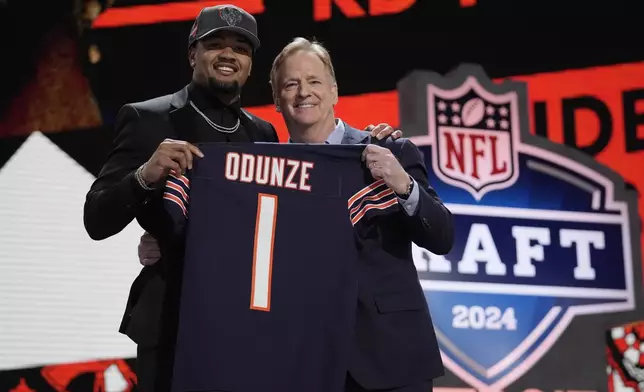 Washington wide receiver Rome Odunze, left, poses with NFL Commissioner Roger Goodell after being chosen by the Chicago Bears with the ninth overall pick during the first round of the NFL football draft, Thursday, April 25, 2024, in Detroit. (AP Photo/Jeff Roberson)