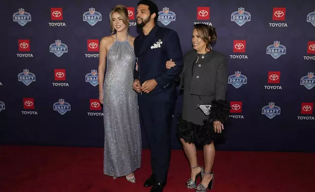 Southern California quarterback Caleb Williams, center, poses on the red carpet ahead of the first round of the NFL football draft, Thursday, April 25, 2024, in Detroit. (AP Photo/Carlos Osorio)