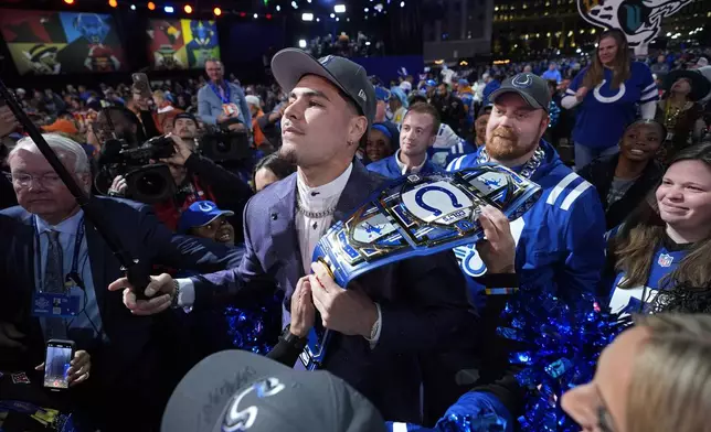 UCLA defensive lineman Laiatu Latu poses with fans after being chosen by the Indianapolis Colts with the 15th overall pick during the first round of the NFL football draft, Thursday, April 25, 2024, in Detroit. (AP Photo/Paul Sancya)