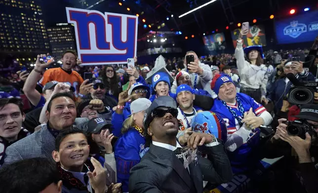 LSU wide receiver Malik Nabers celebrates with fans after being chosen by the New York Giants with the sixth overall pick during the first round of the NFL football draft, Thursday, April 25, 2024, in Detroit. (AP Photo/Paul Sancya)