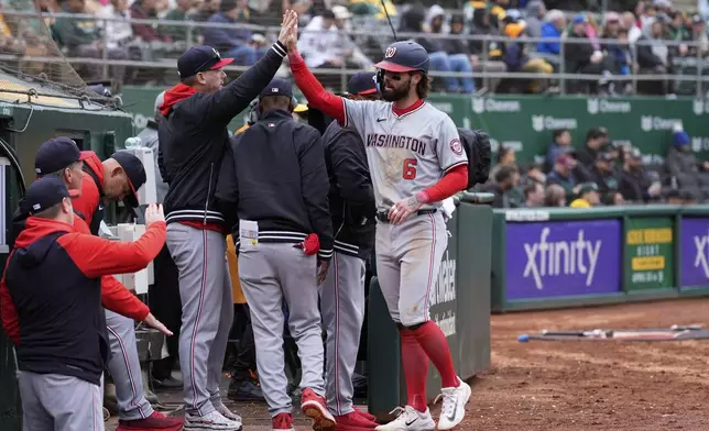 Washington Nationals' Jesse Winker (6) celebrates with teammates at the dugout after scoring against the Oakland Athletics on Luis García Jr.'s double during the sixth inning of a baseball game Saturday, April 13, 2024, in Oakland, Calif. (AP Photo/Godofredo A. Vásquez)