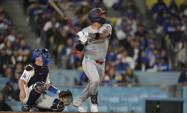 Washington Nationals' Luis Garcia Jr., right, follows through on his three-run home run during the fifth inning of a baseball game against the Los Angeles Dodgers, Monday, April 15, 2024, in Los Angeles. (AP Photo/Marcio Jose Sanchez)