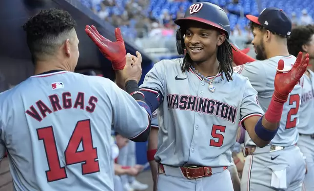 Washington Nationals' CJ Abrams (5) is congratulated by Ildemaro Vargas (14) after hitting a two-run home run during the third inning of a baseball game against the Miami Marlins, Monday, April 29, 2024, in Miami. (AP Photo/Lynne Sladky)