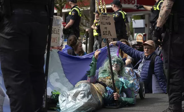 Protestors partially blocked a road during a climate protest of Extinction Rebellion and other activists near the Dutch parliament in The Hague, Netherlands, Saturday, April 6, 2024. (AP Photo/Peter Dejong)