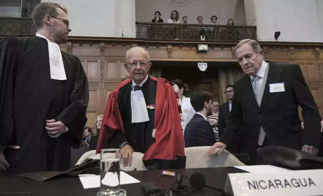 Nicaragua's Ambassador Carlos Jose Arguello Gomez, right, and Alain Pellet, center, a lawyer representing Nicaragua, arrive for the start of a two days hearing at the World Court in The Hague, Netherlands, Monday, April 8, 2024, in a case brought by Nicaragua accusing Germany of breaching the genocide convention by providing arms and support to Israel. (AP Photo/Patrick Post)