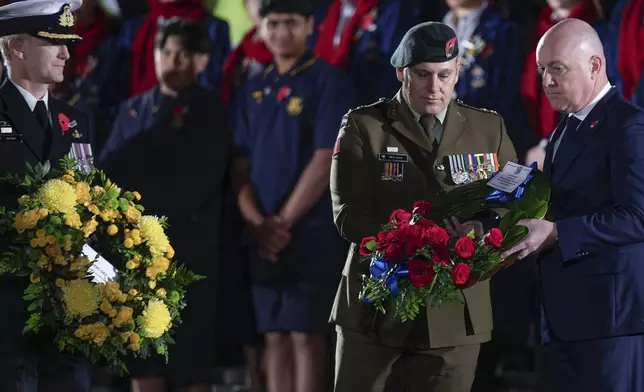 New Zealand Prime Minister Christopher Luxon, right, lays a wreath at the Anzac Day dawn service at the Auckland War Memorial Museum in Auckland, New Zealand, Thursday, April 25, 2024. (Hayden Woodward /NZ Herald via AP)