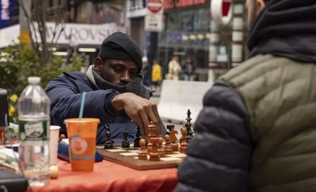Tunde Onakoya, 29, a Nigerian chess champion and child education advocate, plays a chess game in Times Square, Friday, April 19, 2024 in New York. (AP Photo/Yuki Iwamura)