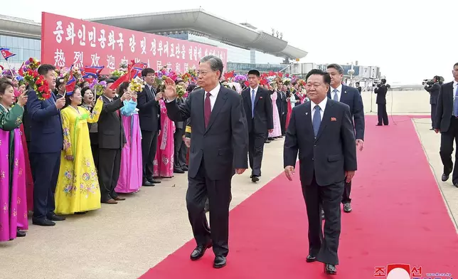 In this photo provided on April 12, 2024, by the North Korean government, Zhao Leji, center, chairman of the National People’s Congress of China waves, escorted by Choe Ryong Hae, right, vice-chairman of the central committee of the Workers' Party of North Korea, as Zhao arrived at Pyongyang International Airport in Pyongyang, North Korea, on April 11, 2024. Korean language watermark on image as provided by source reads: "KCNA" which is the abbreviation for Korean Central News Agency.(Korean Central News Agency/Korea News Service via AP)