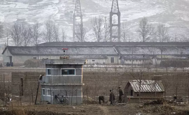 FILE - North Korean soldiers chat outside their post near the North Korean town of Sinuiju, opposite side to the Chinese border city of Dandong, on Dec. 21, 2011. North Korea is putting surveillance cameras in schools and workplaces, and collecting fingerprints, photographs and other biometric information from its citizens in a technology-driven push to monitor its population even more closely, a report said Tuesday, April 16, 2024. (AP Photo/Andy Wong, File)