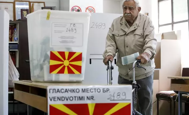An elderly man comes from voting booth to cast his ballot for the presidential election at a polling station in Skopje, North Macedonia, on Wednesday, April 24, 2024. People are lining up at pools to cast their votes in a peaceful atmosphere, hoping that the next president will be able to bring the country into the European Union. (AP Photo/Boris Grdanoski)