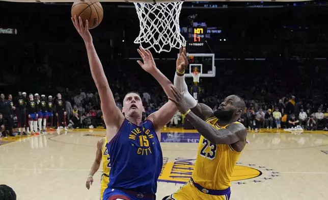 Denver Nuggets center Nikola Jokic (15) shoots against Los Angeles Lakers forward LeBron James (23) during the second half of Game 3 of an NBA basketball first-round playoff series in Los Angeles, Thursday, April 25, 2024. (AP Photo/Ashley Landis)