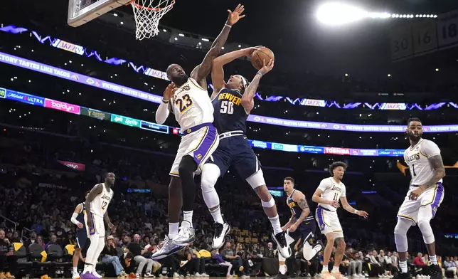 Denver Nuggets forward Aaron Gordon (50) shoots as Los Angeles Lakers forward LeBron James (23) defends during the first half in Game 4 of an NBA basketball first-round playoff series Saturday, April 27, 2024, in Los Angeles. (AP Photo/Mark J. Terrill)