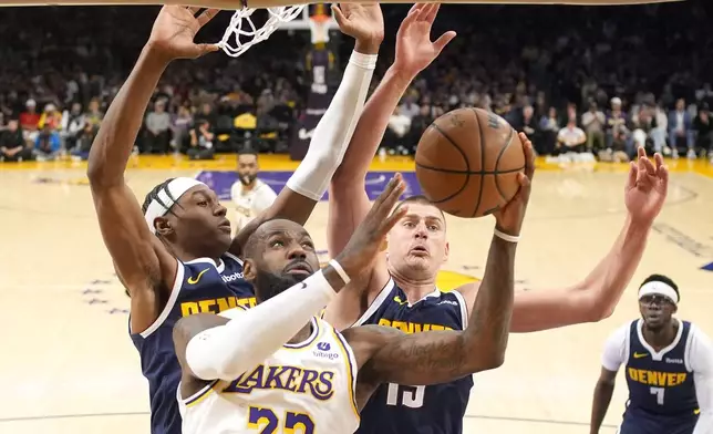 Los Angeles Lakers forward LeBron James (23) shoots as Denver Nuggets forward Peyton Watson (8) and center Nikola Jokic defend during the first half in Game 4 of an NBA basketball first-round playoff series Saturday, April 27, 2024, in Los Angeles. (AP Photo/Mark J. Terrill)