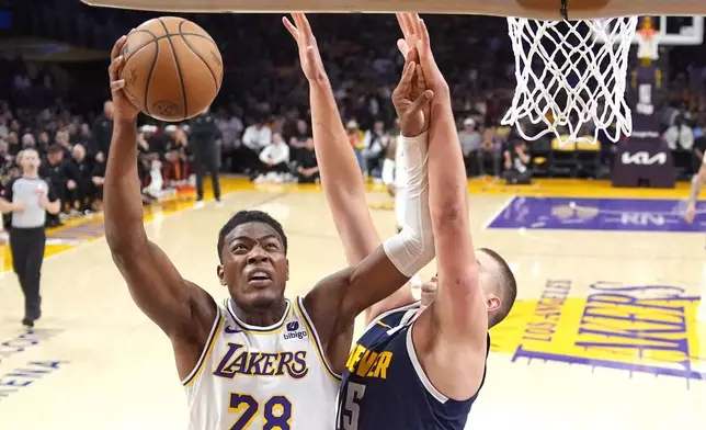 Los Angeles Lakers forward Rui Hachimura, left, shoots as Denver Nuggets center Nikola Jokic defends during the first half in Game 4 of an NBA basketball first-round playoff series Saturday, April 27, 2024, in Los Angeles. (AP Photo/Mark J. Terrill)