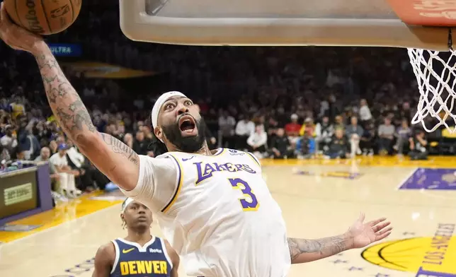 Los Angeles Lakers forward Anthony Davis, right, shoots as Denver Nuggets forward Peyton Watson watches during the first half in Game 4 of an NBA basketball first-round playoff series Saturday, April 27, 2024, in Los Angeles. (AP Photo/Mark J. Terrill)