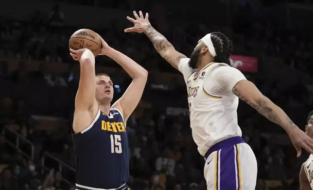 Denver Nuggets center Nikola Jokic, left, shoots as Los Angeles Lakers forward Anthony Davis defends during the first half in Game 4 of an NBA basketball first-round playoff series Saturday, April 27, 2024, in Los Angeles. (AP Photo/Mark J. Terrill)