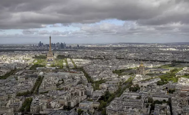 The Eiffel Tower and the Champs-de-Mars at its feet, the Invalides monument and its dome, right, are seen Monday, April 15, 2024 in Paris. The Champ-de-Mars will host the Beach Volleyball and Blind Football and the Invalides will host the Cycling road, Archery and Athetics events at the Paris 2024 Olympic and Paralympic Games. (AP Photo/Aurelien Morissard)