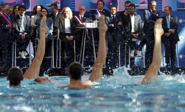French President Emmanuel Macron, center, and officials attend the inauguration of the Olympic Aquatics Center (CAO) in Saint-Denis, near Paris, Thursday, April 4, 2024. The aquatic center will host the artistic swimming, water polo and diving events during the Paris 2024 Olympic Games. (Gonzalo Fuentes/Pool via AP)