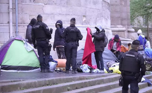 Miigrants are being evicted from a makeshift camp, Tuesday, April 30, 2024 in Paris. Similar operations are carried out by the police authorities on a daily basis in the months leading to the Olympics. (AP Photo/Michel Euler)