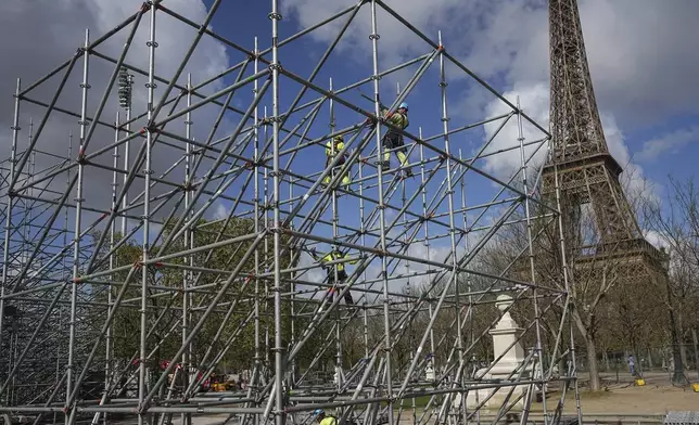 Workers build constructions on the Champ-de-Mars, near the Eiffel Tower, ahead of the Paris 2024 Olympic Games, Wednesday, April 10, 2024 in Paris. (AP Photo/Laurent Cipriani, File)