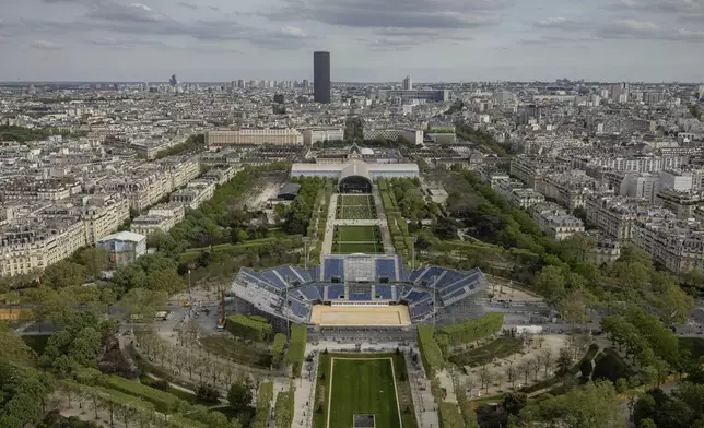 Stands are under construction on the Champ-de-Mars,with the Grand Palais Ephemere in background, Sunday, April 14, 2024 in Paris. The Champ-de-Mars stadium will host the Beach Volleyball and Blind Football at the Paris 2024 Olympic and Paralympic Games. In background is the Grand Palais Ephemere, or Champ de Mars Arena, will host Judo and Wrestling for the Paris 2024 Olympic Games (AP Photo/Aurelien Morissard, File)