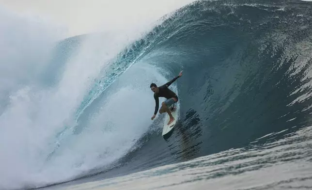 A surfer rides a wave in Teahupo'o, Tahiti, French Polynesia, Saturday, Jan. 13, 2024. The world-famous surf spot is set to host the 2024 Paris Olympics surfing competition. (AP Photo/Daniel Cole, File)