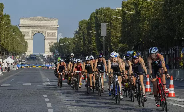 Riders on the first bike leg compete on the Champs Elysee avenue of the women's triathlon test event for the Paris 2024 Olympic Games in Paris, Thursday, Aug. 17, 2023. (AP Photo/Michel Euler, File)