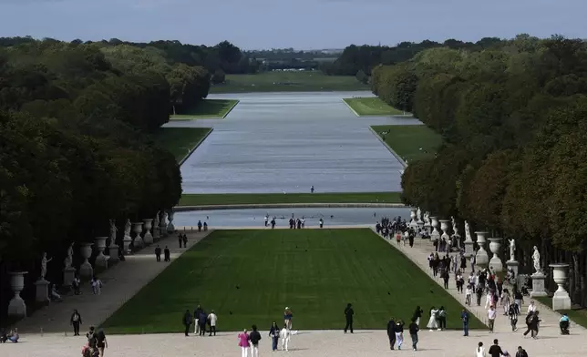 Visitors stroll in the park of the Chateau de Versailles, outside Paris, France, Tuesday, Sept.19, 2023. The park of the Chateau de Versailles will host the equestrian events at the Paris 2024 Olympic Games. (AP Photo/Christophe Ena, File)