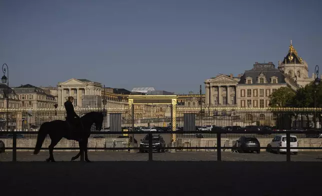 Laure Guillaume, 44, horsewoman and coordinator at the AcadÈmie du Spectacle Equestre trains with her horse in the main courtyard of the royal stables, in Versailles, Thursday, April 25, 2024. More than 340 years after the royal stables were built under the reign of France's Sun King, riders and horses continue to train and perform in front of the Versailles Palace. The site will soon keep on with the tradition by hosting the equestrian sports during the Paris Olympics. Commissioned by King Louis XIV, the stables have been built from 1679 to 1682 opposite to the palace's main entrance. (AP Photo/Aurelien Morissard)