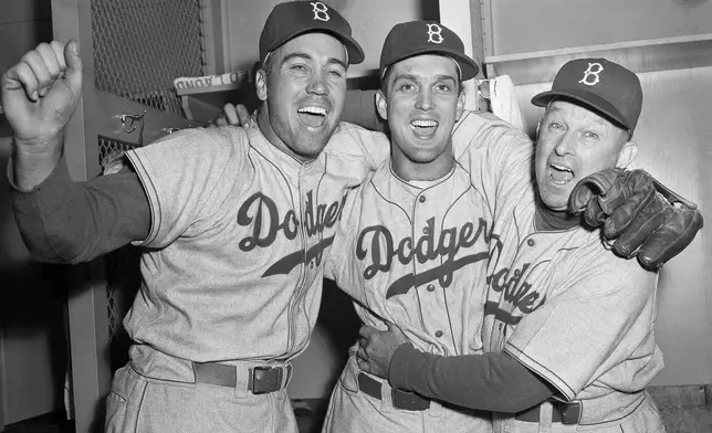 FILE - Brooklyn Dodgers pitcher Carl Erskine, center, celebrates with teammate Duke Snider, left, and manager Charley Dressen after beating the Yankees 6-5 in Game 5 of the World Series at Yankee Stadium in New York, Oct. 5, 1952. Carl Erskine, who pitched two no-hitters as a mainstay on the Brooklyn Dodgers and was a 20-game winner in 1953 when he struck out a then-record 14 in the World Series, died Tuesday, April 16, 2024, at Community Hospital Anderson in Anderson, Indiana, according to Michele Hockwalt, the hospital's marketing and communication manager. He was 97. (AP Photo)