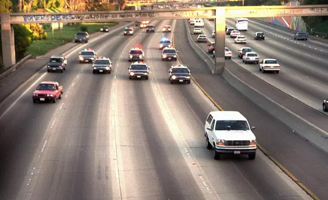 FILE - In this June 17, 1994, file photo, a white Ford Bronco, driven by Al Cowlings carrying O.J. Simpson, is trailed by Los Angeles police cars as it travels on a freeway in Los Angeles. Simpson, the decorated football superstar and Hollywood actor who was acquitted of charges he killed his former wife and her friend but later found liable in a separate civil trial, has died. He was 76. (AP Photo/Joseph Villarin, File)